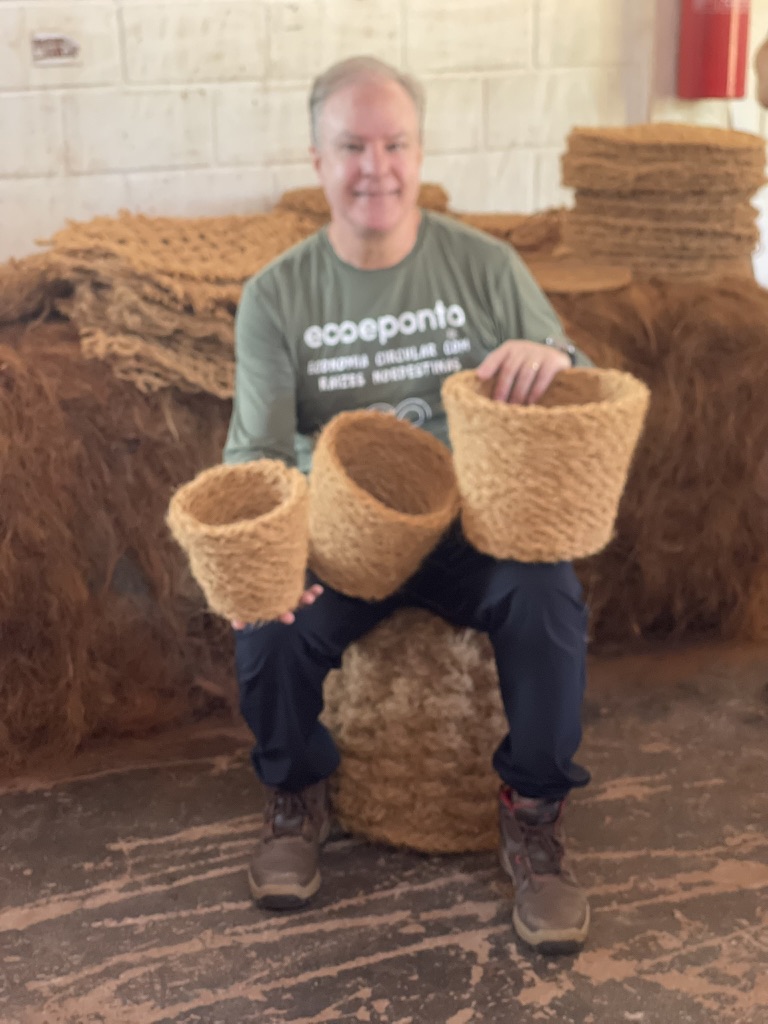 Fundador da Eco e Ponto segurando vasos de fibra de coco